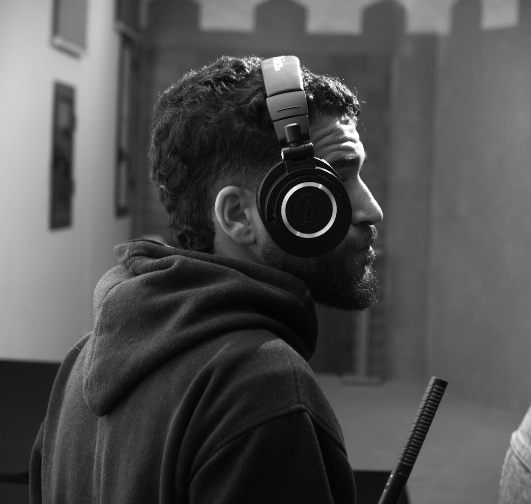 Smiling podcaster woman wearing headphones in a recording studio
